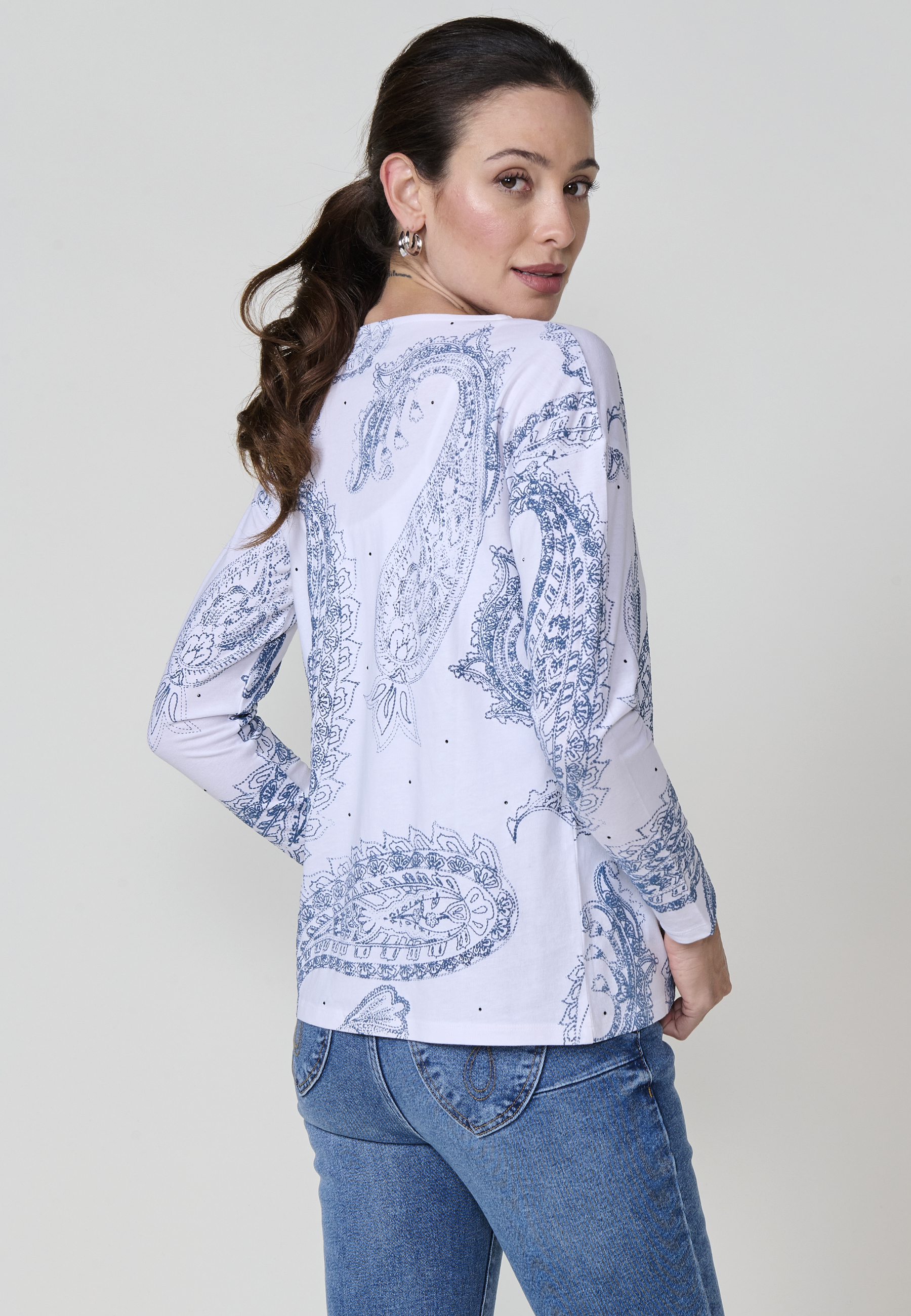 Camiseta blanca de mujer en algodón 100% con cuello redondo, manga larga, estampado cachemira en relieve y detalles brillantes. Logo metálico Koröshi en el frontal.