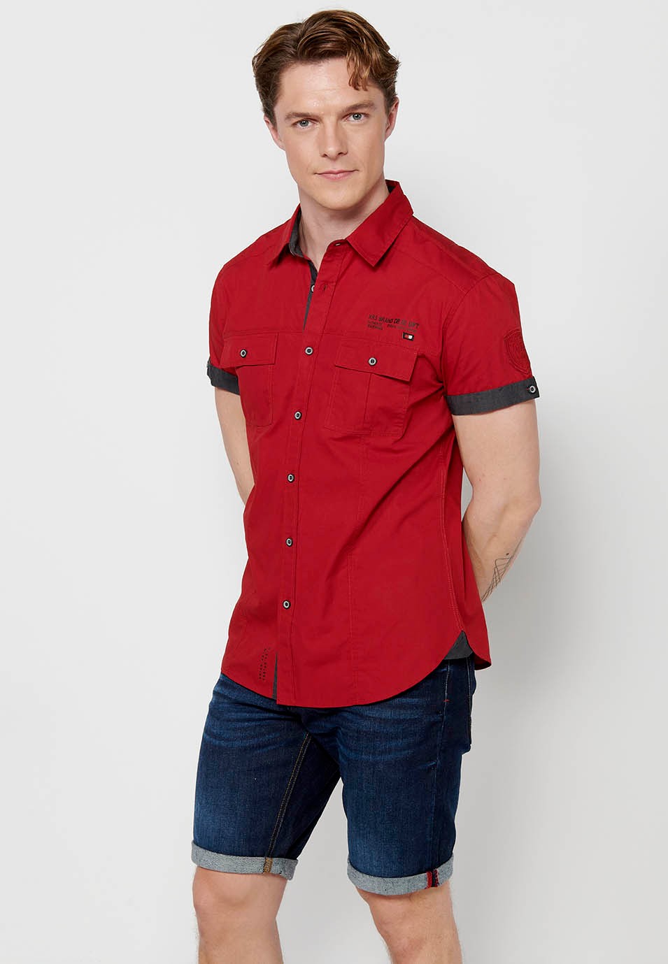 Chemise en coton à manches courtes avec fermeture boutonnée sur le devant et poches à rabat avant de couleur rouge pour homme