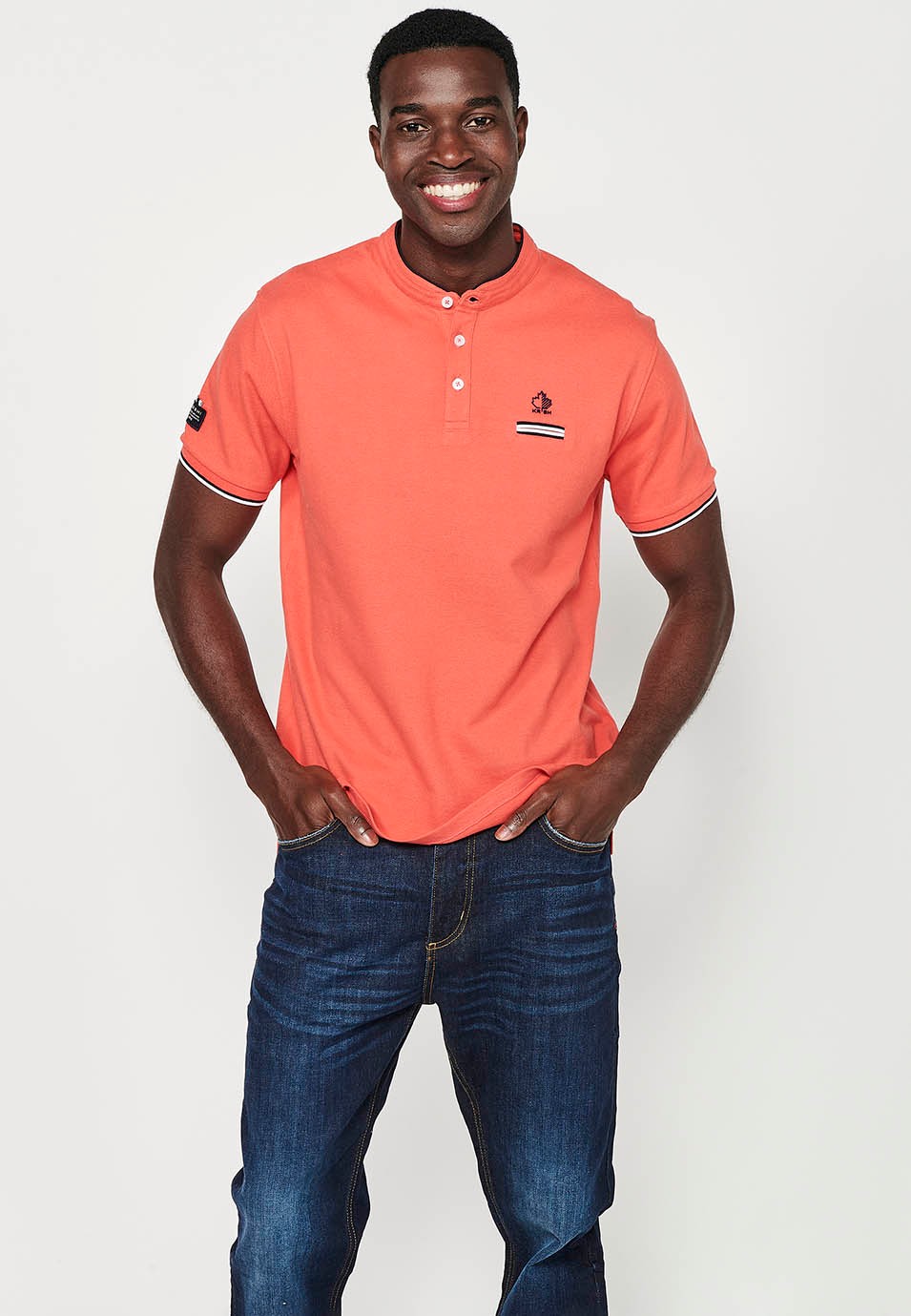 Short-sleeved cotton polo shirt with ribbed finish with round neck with buttoned opening and side slits in coral color for men