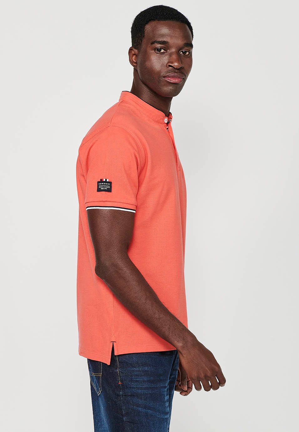 Short-sleeved cotton polo shirt with ribbed finish with round neck with buttoned opening and side slits in coral color for men 3