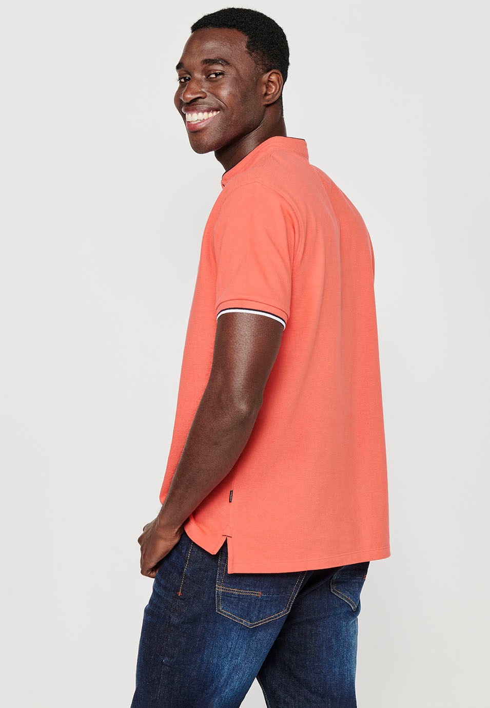 Short-sleeved cotton polo shirt with ribbed finish with round neck with buttoned opening and side slits in coral color for men 1