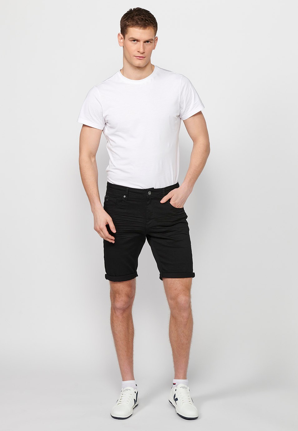 Denim Bermuda shorts with cuffed finish and front zipper and button closure. Five pockets, one black color pocket for men