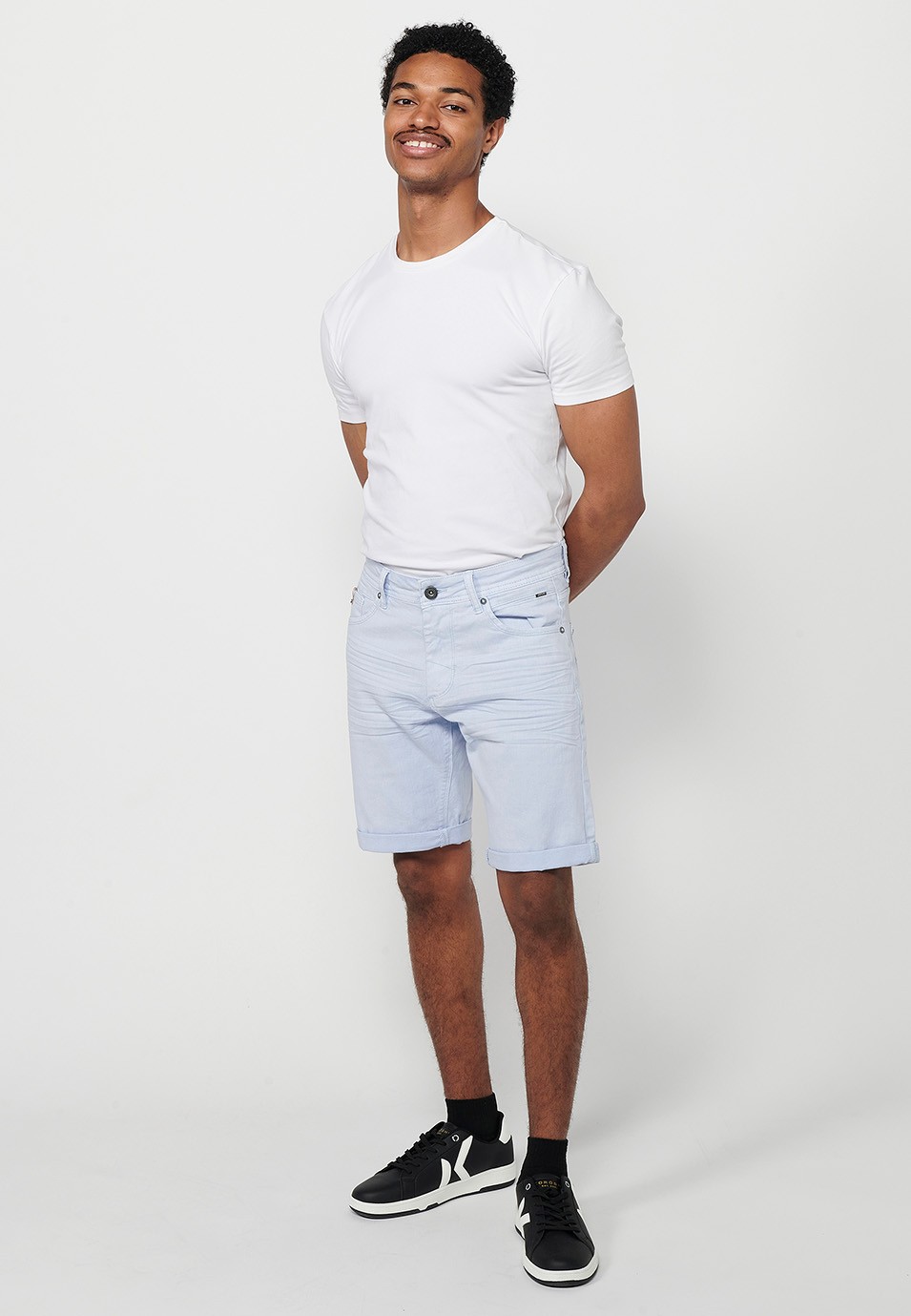 Bermuda en denim avec finition à revers et fermeture éclair et bouton sur le devant. Cinq poches, une poche de couleur bleue pour les hommes