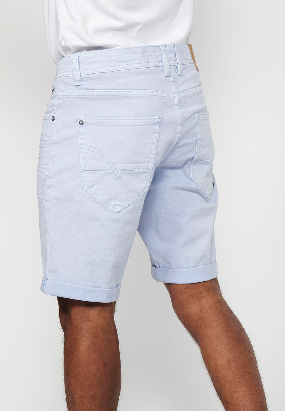 Denim Bermuda shorts with cuffed finish and front zipper and button closure. Five pockets, one blue color pocket for men 4