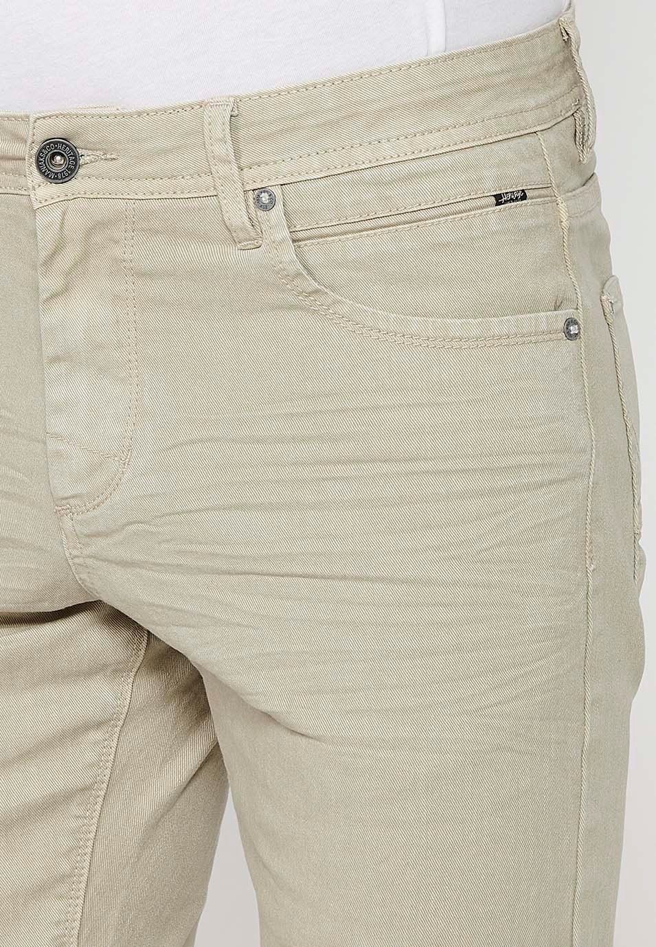 Pantalón corto Bermuda vaquera con acabado en vuelta con Cierre delantero con cremallera y botón. Cinco bolsillos, uno cerillero de Color Piedra para Hombre 7