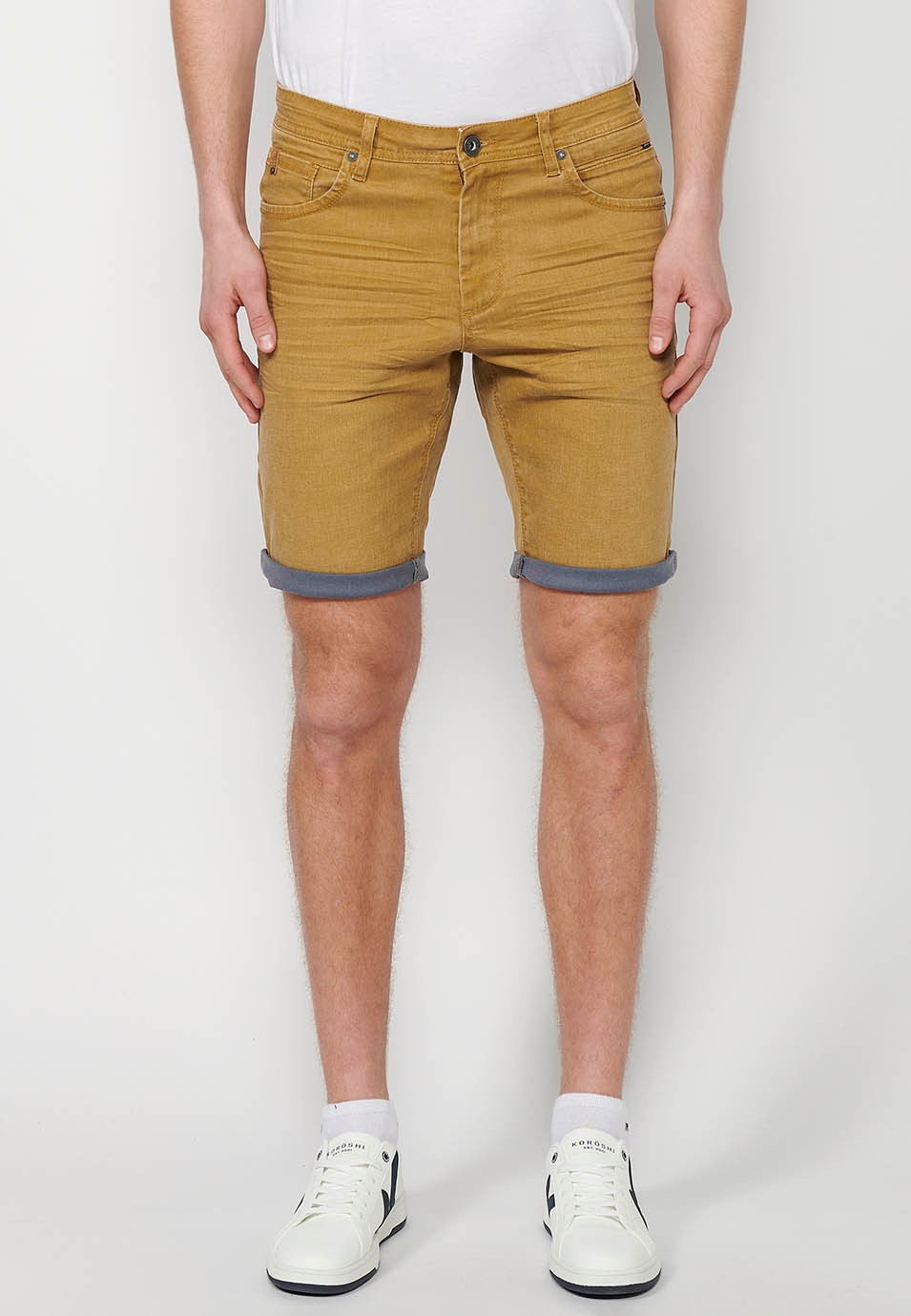 Pantalón corto Bermuda Vaquera con acabado en vuelta de Cierre delantero con cremallera y botón con Cinco bolsillos, uno cerillero de Color Ocre para Hombre 3