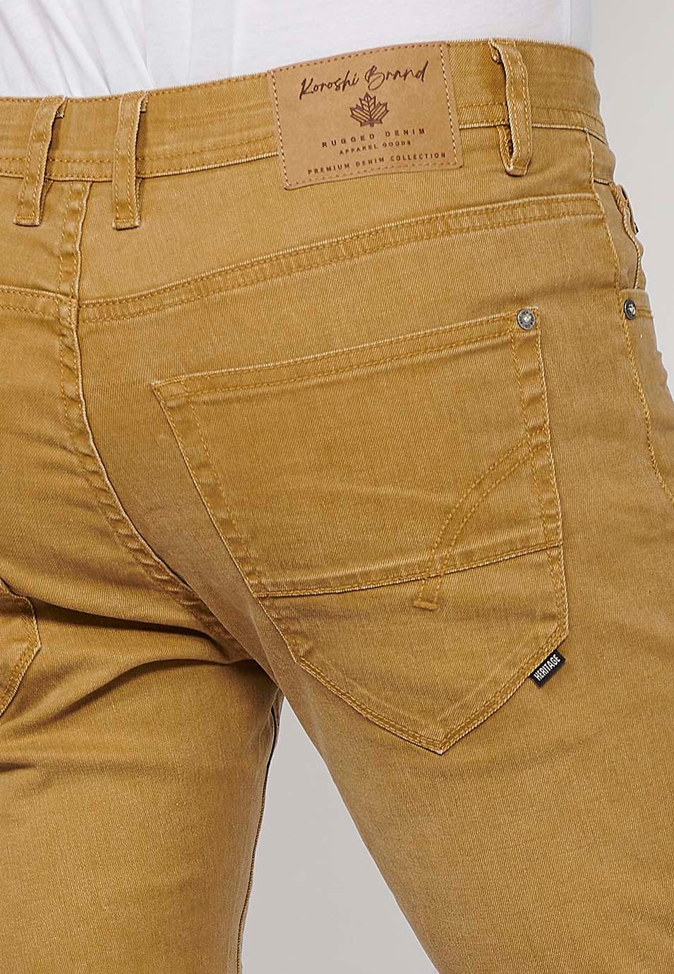 Pantalón corto Bermuda Vaquera con acabado en vuelta de Cierre delantero con cremallera y botón con Cinco bolsillos, uno cerillero de Color Ocre para Hombre 7