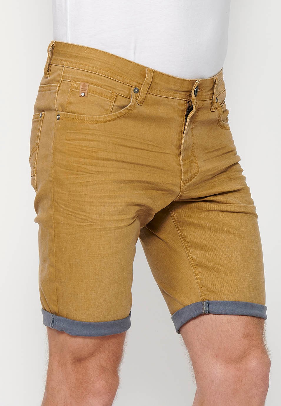 Pantalón corto Bermuda Vaquera con acabado en vuelta de Cierre delantero con cremallera y botón con Cinco bolsillos, uno cerillero de Color Ocre para Hombre 6