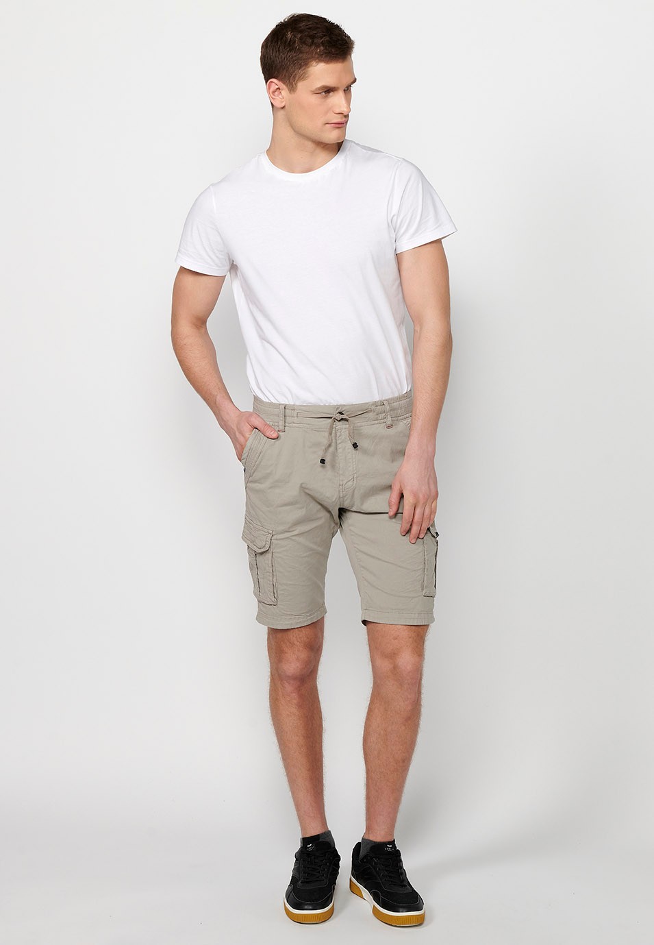 Cargo shorts with front closure with zipper and button and four pockets, two back pockets with flap with two cargo pockets with flap and adjustable waist with drawstring in Stone Color for Men