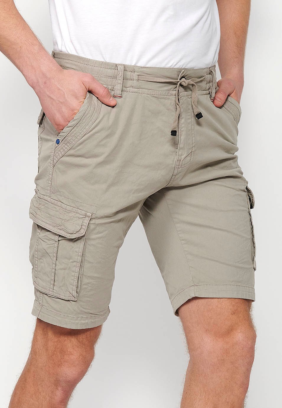 Cargo shorts with front closure with zipper and button and four pockets, two back pockets with flap with two cargo pockets with flap and adjustable waist with drawstring in Stone Color for Men