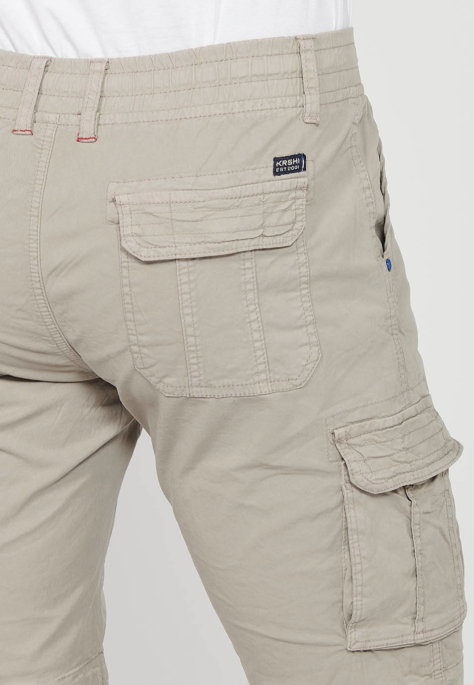 Pantalón corto cargo con Cierre delantero con cremallera y botón y Cuatro bolsillos, dos traseros con solapa con Dos bolsillos cargo con solapa y Cintura ajustable con cordón de Color Piedra para Hombre