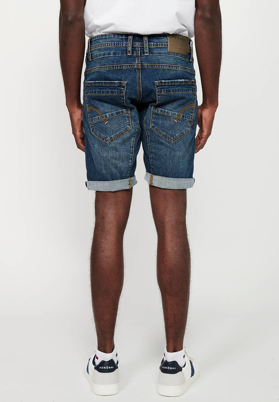 Bermuda en jean avec finition à revers et fermeture éclair sur le devant et fermeture boutonnée avec cinq poches, une poche avec détails bleus sur le devant pour homme 1