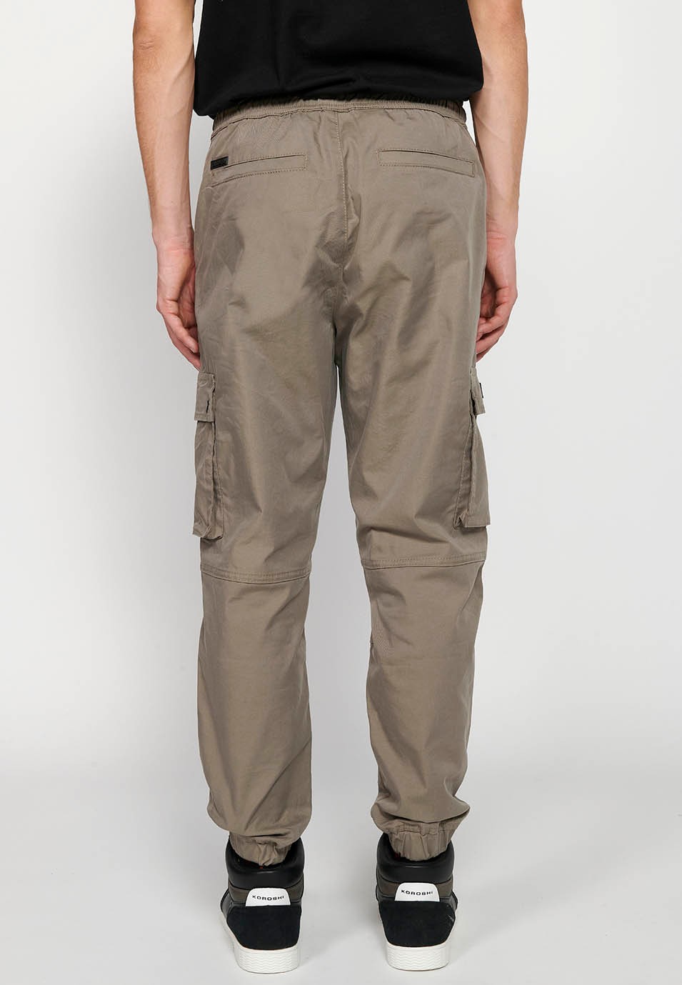 Pantalon de jogging cargo beige avec taille caoutchoutée avec cordon de serrage et poches, deux côtés avec rabat pour homme