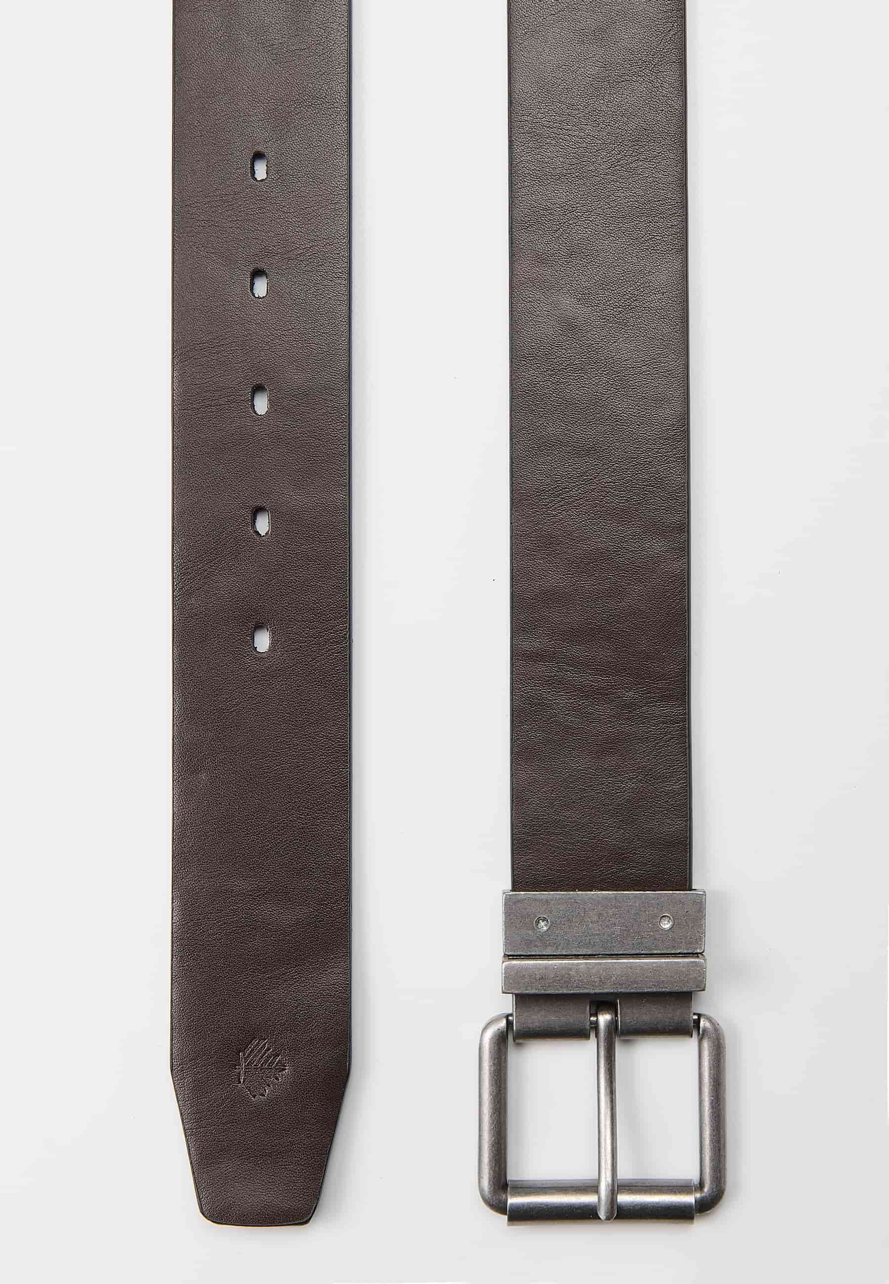 Cinturón reversible con uno de los lados de piel. Cierre con hebilla metálica y pasador color negro y marrón para Hombre
