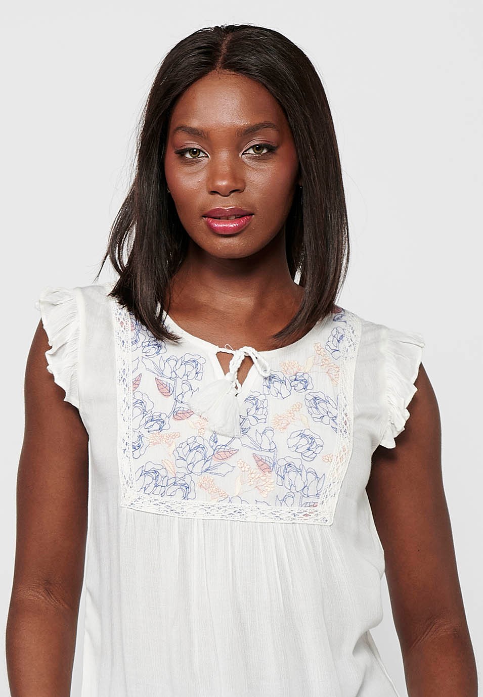 Blouse blanche sans manches brodée de fleurs avec mini volants sur les épaules et sur le devant pour femme 2