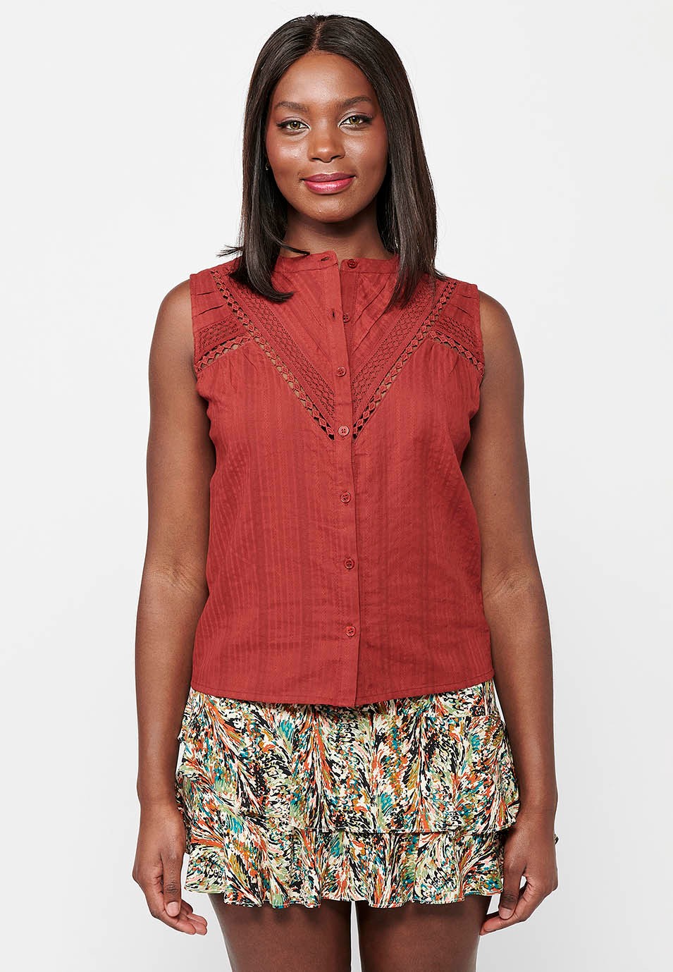 Blouse en coton sans manches avec col rond et fermeture boutonnée sur le devant et détails brodés rouges pour femme 1