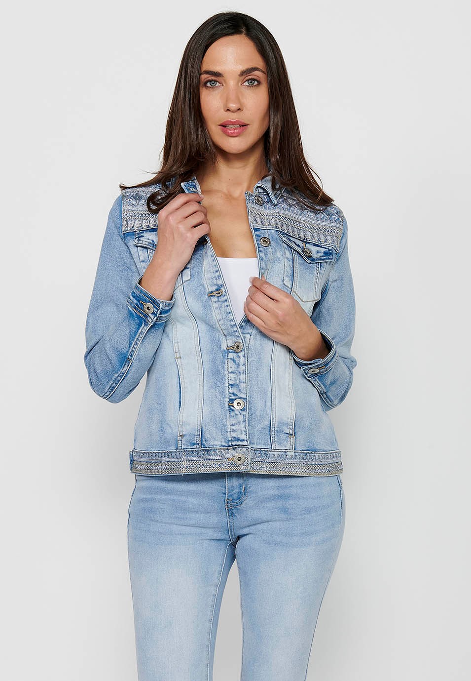 Denim jacket with front closure with buttons and shirt collar with pockets and embroidered details in light blue for women