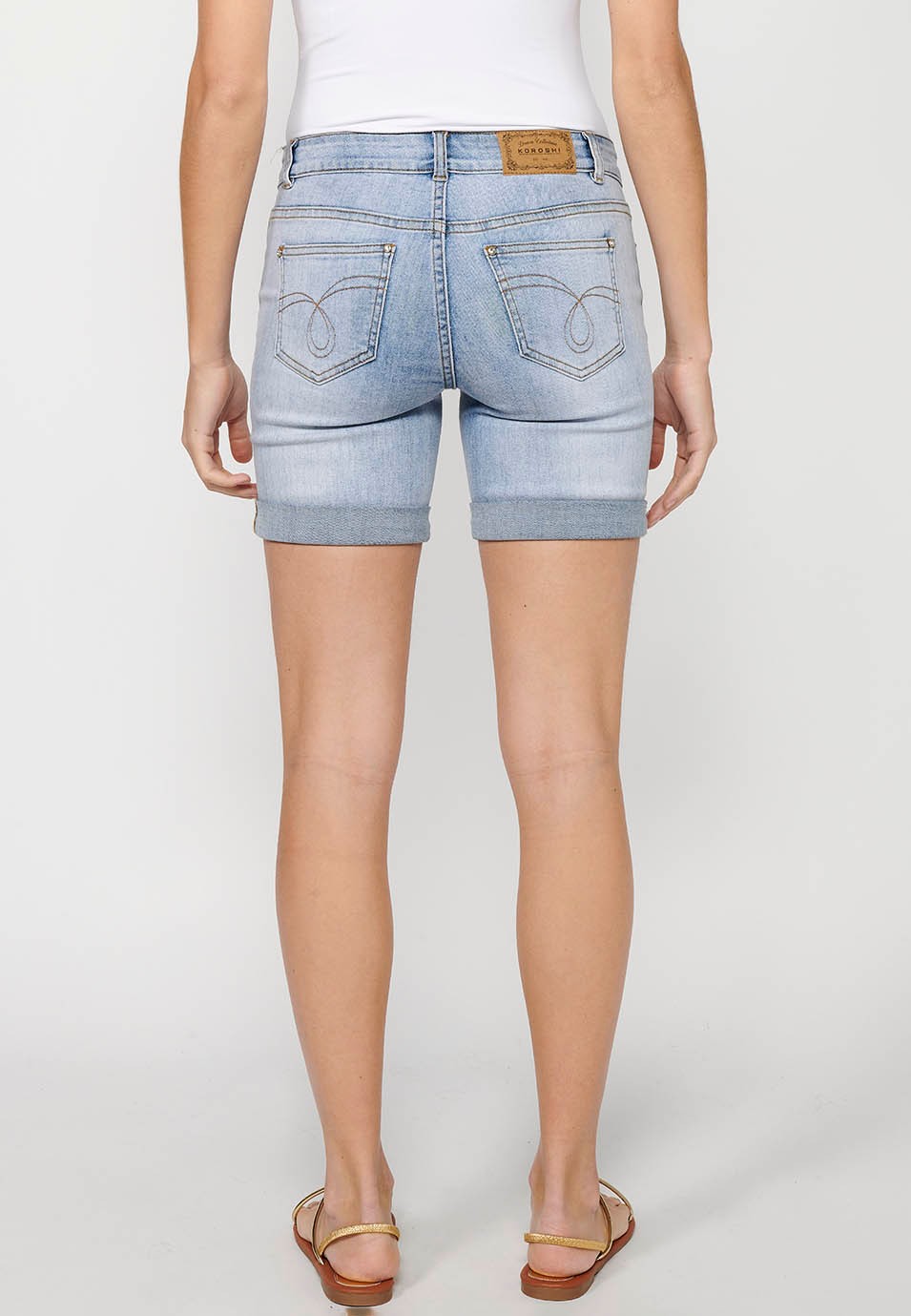 Pantalón corto short denim con cierre delantero con cremallera y botón y detalles bordados florales delanteros con cinco bolsillos, uno cerillero de color azul para mujer | Moda Actual 4