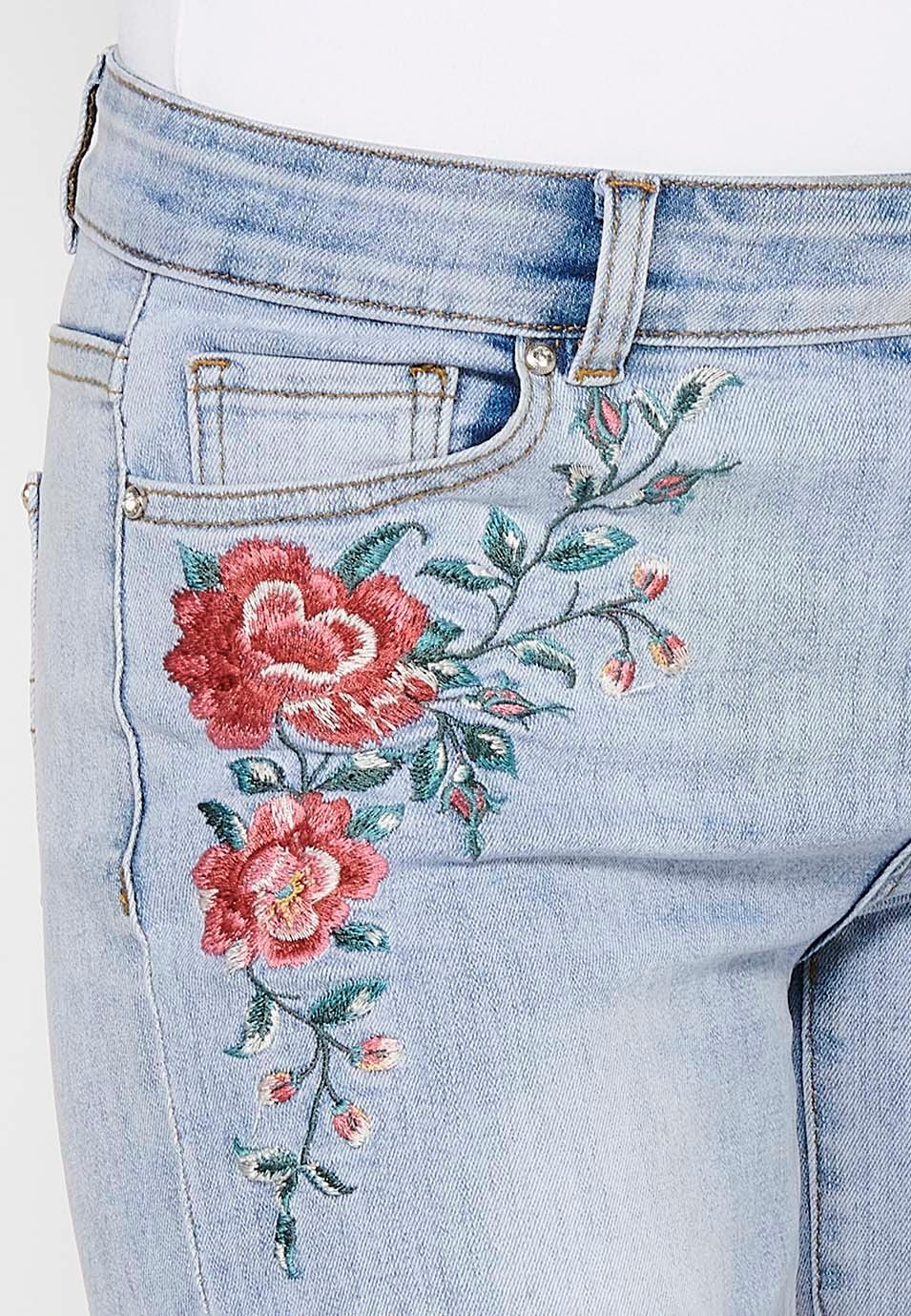 Pantalón corto short denim con cierre delantero con cremallera y botón y detalles bordados florales delanteros con cinco bolsillos, uno cerillero de color azul para mujer | Moda Actual 9