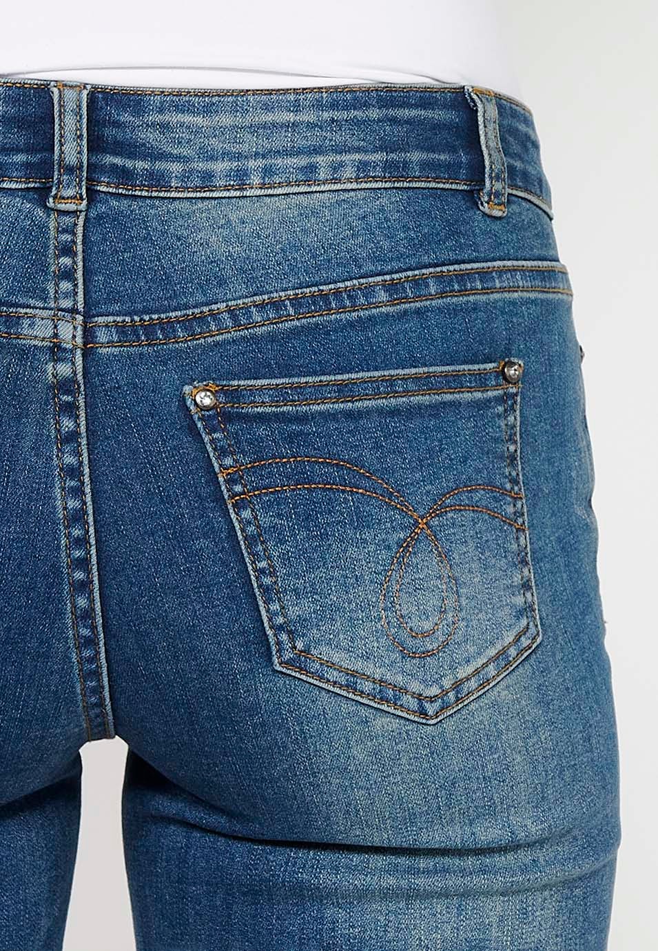 Pantalón corto short denim con cierre delantero con cremallera y botón y detalles bordados florales delanteros con cinco bolsillos, uno cerillero de color azul oscuro para mujer | Moda Actual 5