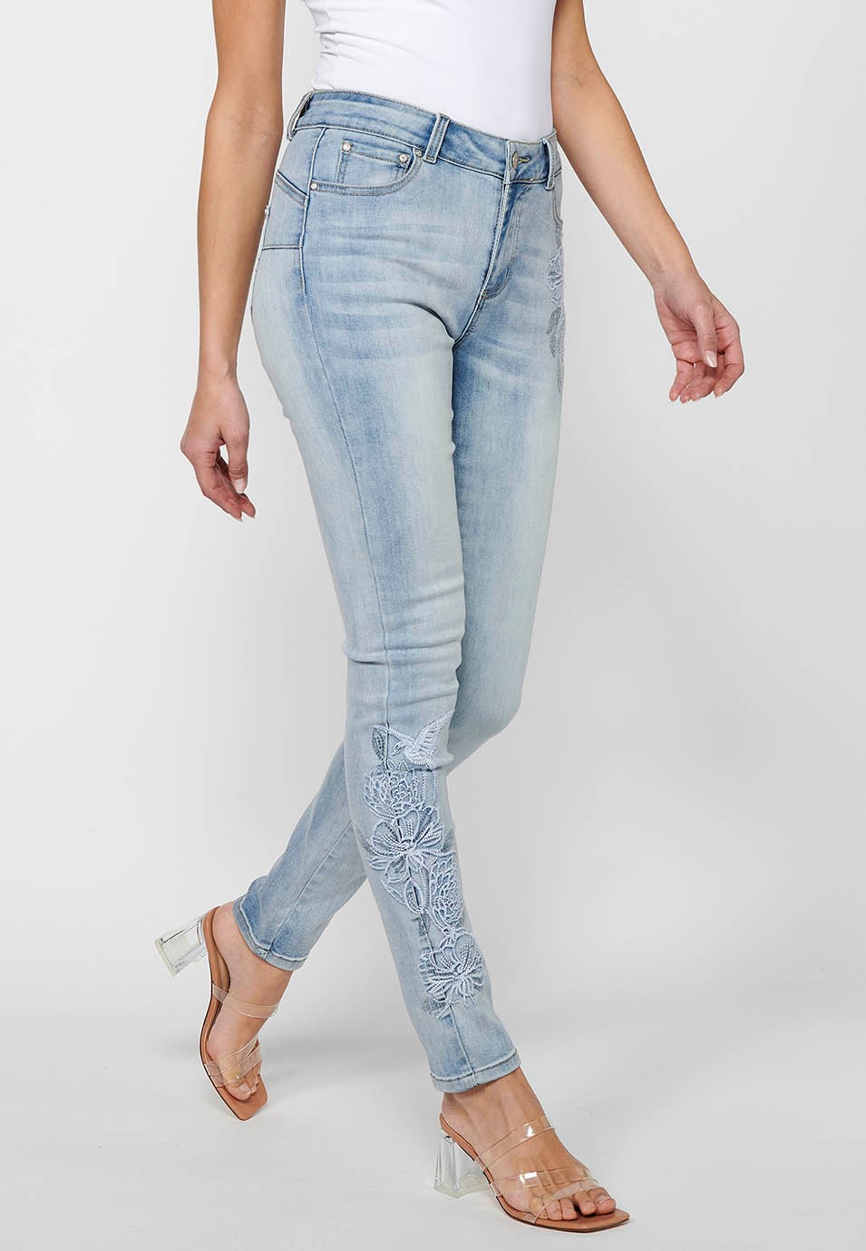 Pantalón largo slim con cierre delantero con cremallera y botón con detalles bordados de color azul claro para mujer | Moda Actual 1