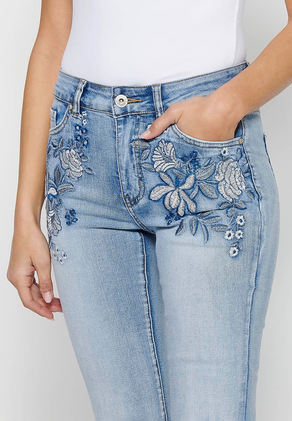 Long flared denim pants with front zipper closure and button with floral front embroidery and five pockets, one light blue pocket for women 8