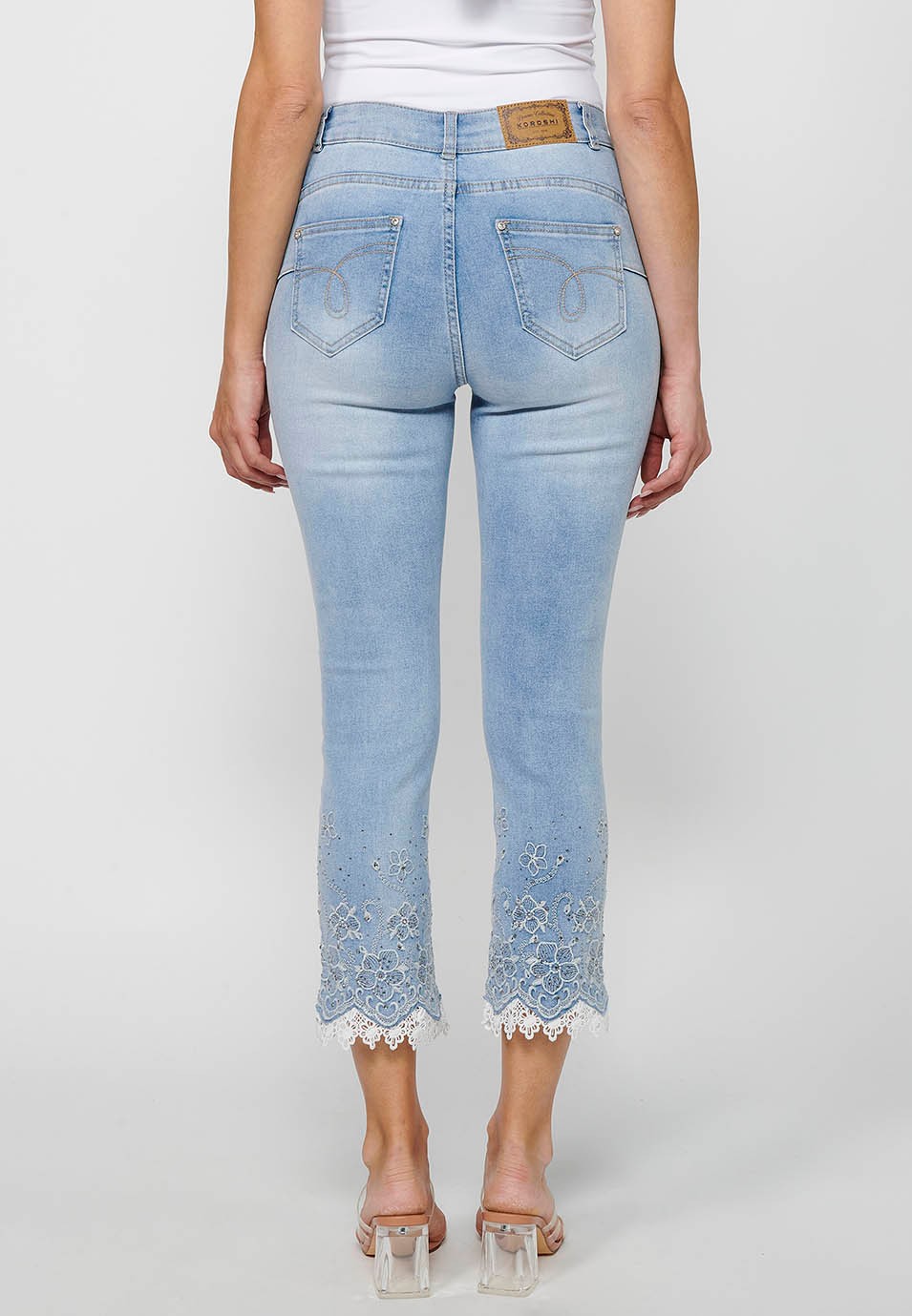 Long slim jeans pants with front zipper closure and light blue floral embroidered details for women 2