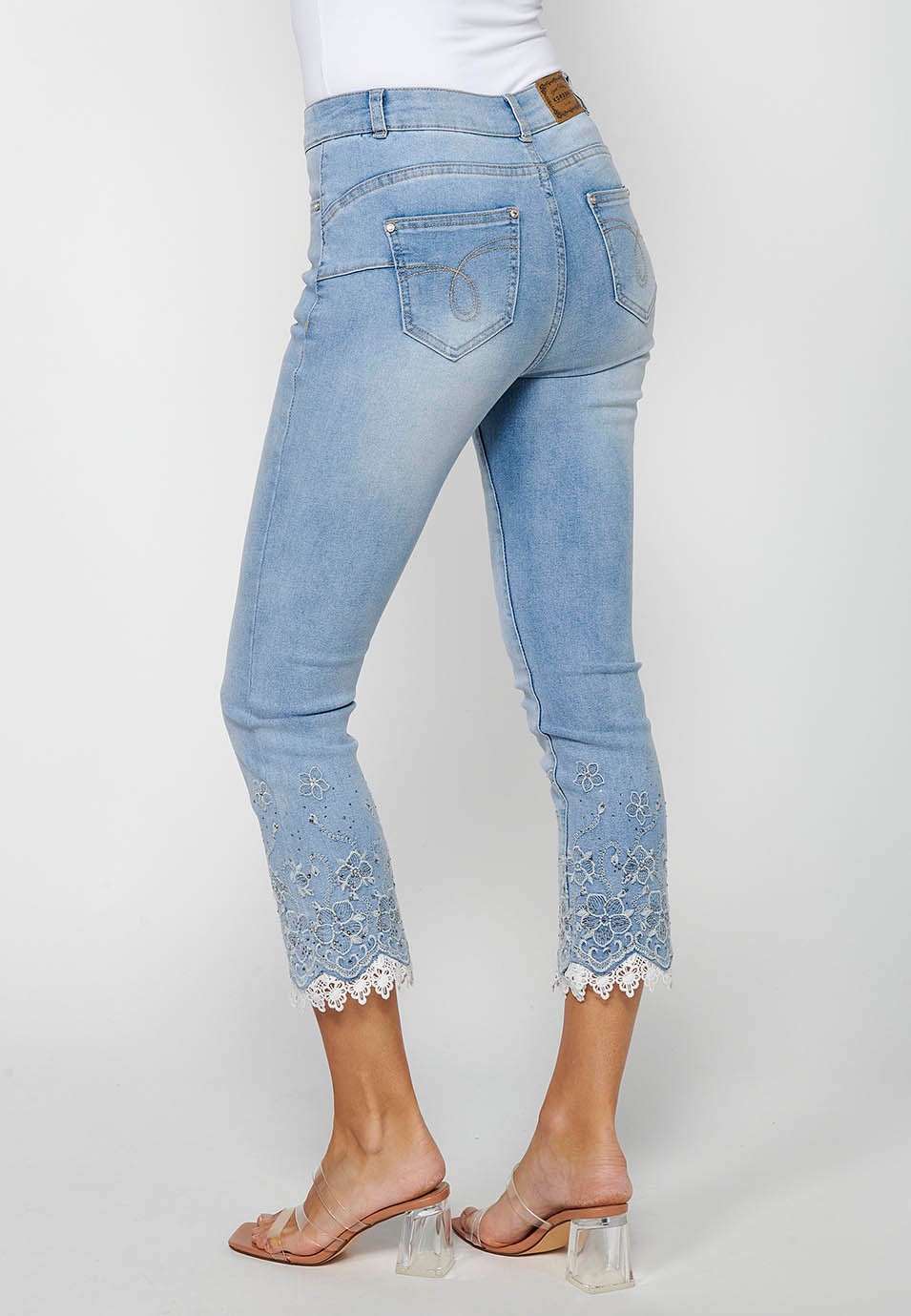 Long slim jeans pants with front zipper closure and light blue floral embroidered details for women 8
