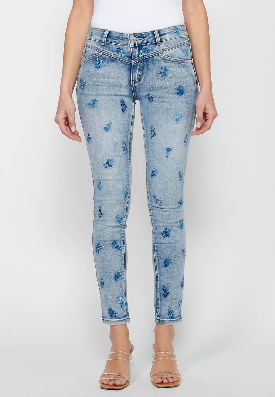 Pantalon long slim avec fermeture éclair sur le devant et fermeture boutonnée avec broderie florale en bleu clair pour femme 1