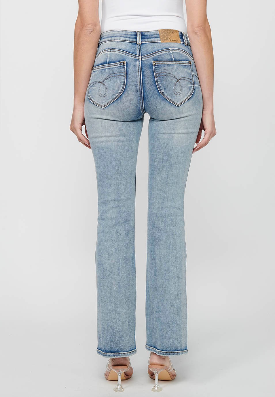 Long bell-bottom pants with front zipper and button closure with light blue ripped details for women 3