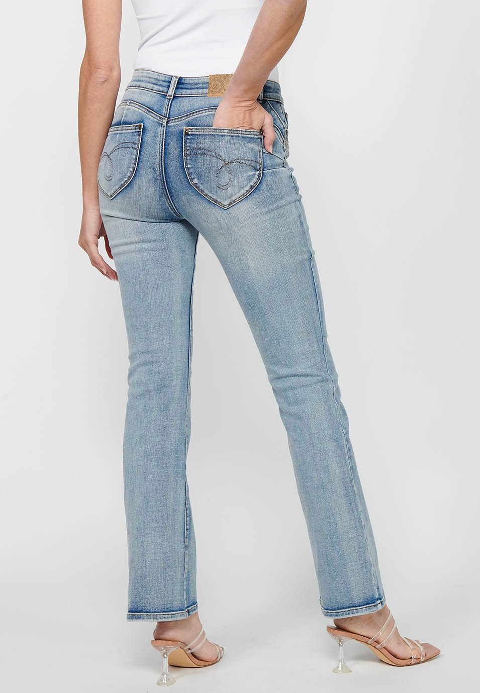 Long bell-bottom pants with front zipper and button closure with light blue ripped details for women 2