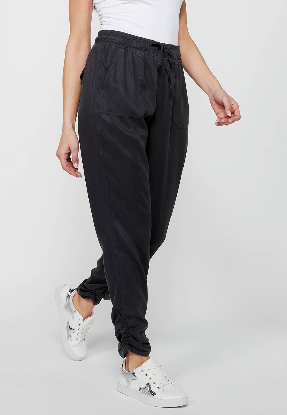 Pantalón largo jogger con acabado rizado y cintura engomada con cuatro bolsillos, dos traseros con solapa de color negro para mujer | Moda Actual 3