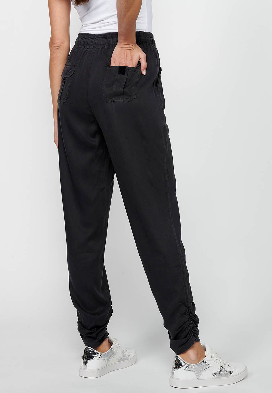 Pantalón largo jogger con acabado rizado y cintura engomada con cuatro bolsillos, dos traseros con solapa de color negro para mujer | Moda Actual 1