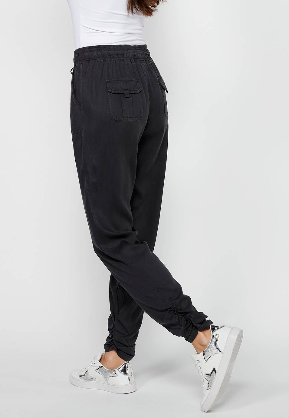 Pantalón largo jogger con acabado rizado y cintura engomada con cuatro bolsillos, dos traseros con solapa de color negro para mujer | Moda Actual 8