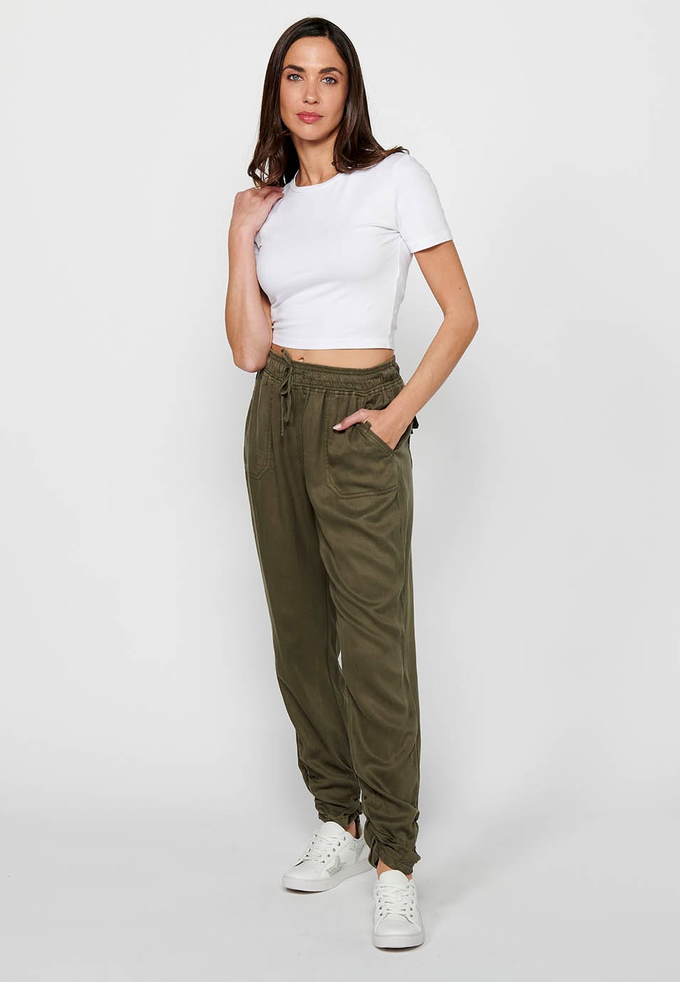 Long jogger pants with curled finish and rubberized waist with four pockets, two rear pockets with flap in Khaki color for women