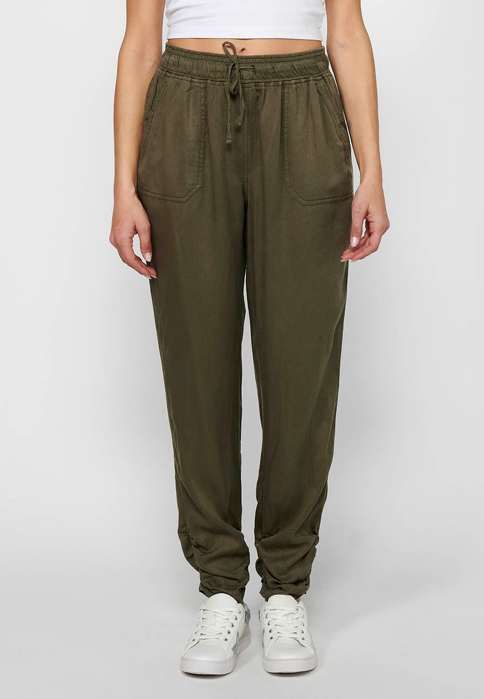 Long jogger pants with curled finish and rubberized waist with four pockets, two rear pockets with flap in Khaki color for women 1