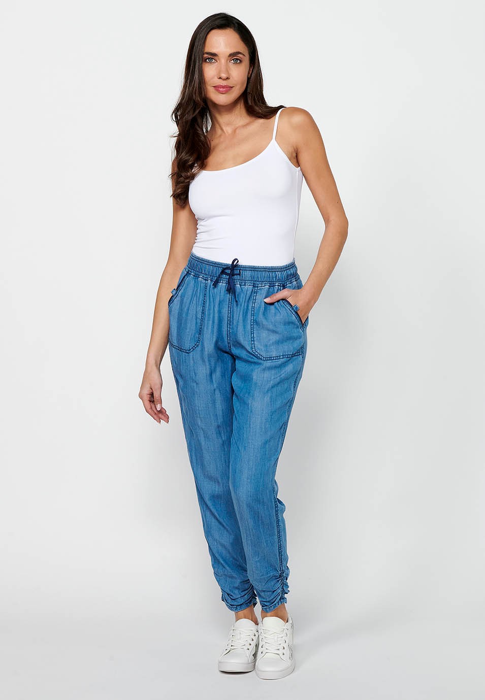 Pantalón largo jogger con acabado rizado y cintura engomada con cuatro bolsillos, dos traseros con solapa de color azul para mujer | Moda Actual