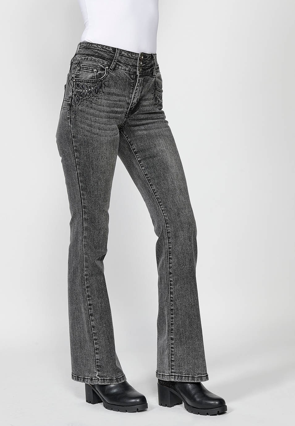 Pantalón largo denim push up acampanado con cinco bolsillos y cierre delantero con cremallera y botón con detalles bordados para mujer de color negro