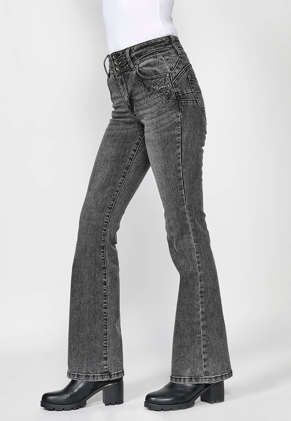 Pantalón largo denim push up acampanado con cinco bolsillos y cierre delantero con cremallera y botón con detalles bordados para mujer de color negro