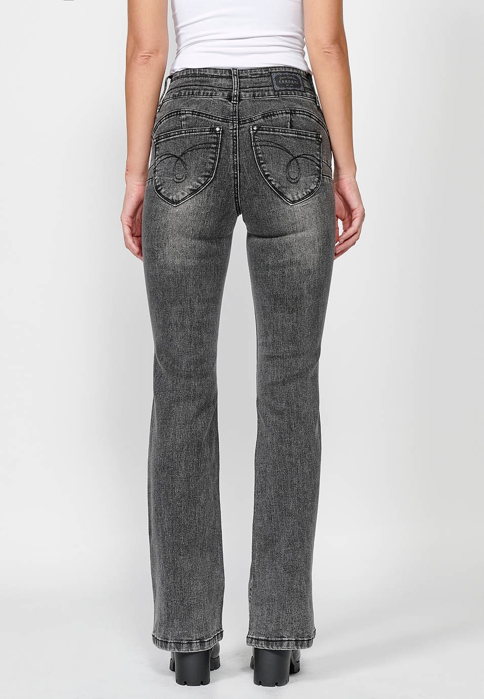Pantalón largo denim push up acampanado con cinco bolsillos y cierre delantero con cremallera y botón con detalles bordados para mujer de color negro
