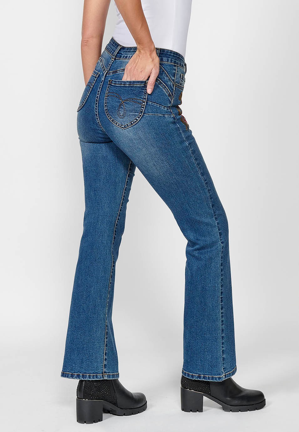 Women's blue flared boot cut denim trousers with five pockets and embroidered flowers on the hip
