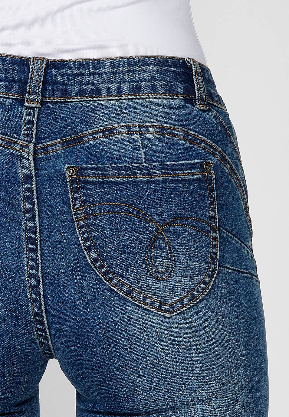 Women's blue flared boot cut denim trousers with five pockets and embroidered flowers on the hip