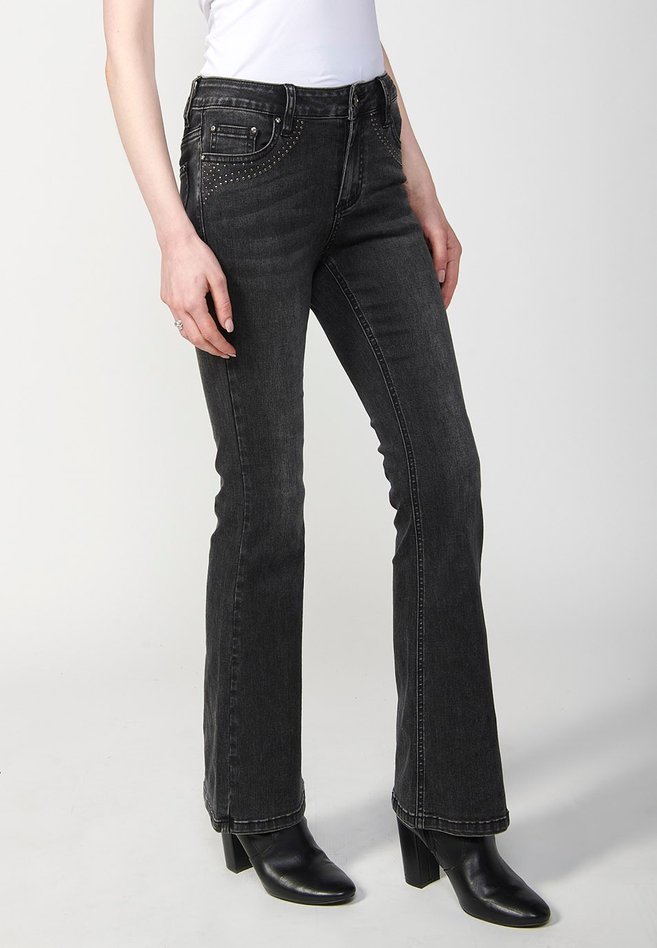 Pantalón denim boot cut cinco bolsillos, campana, color negro, con aplicaciones metalicas en bolsillos para Mujer