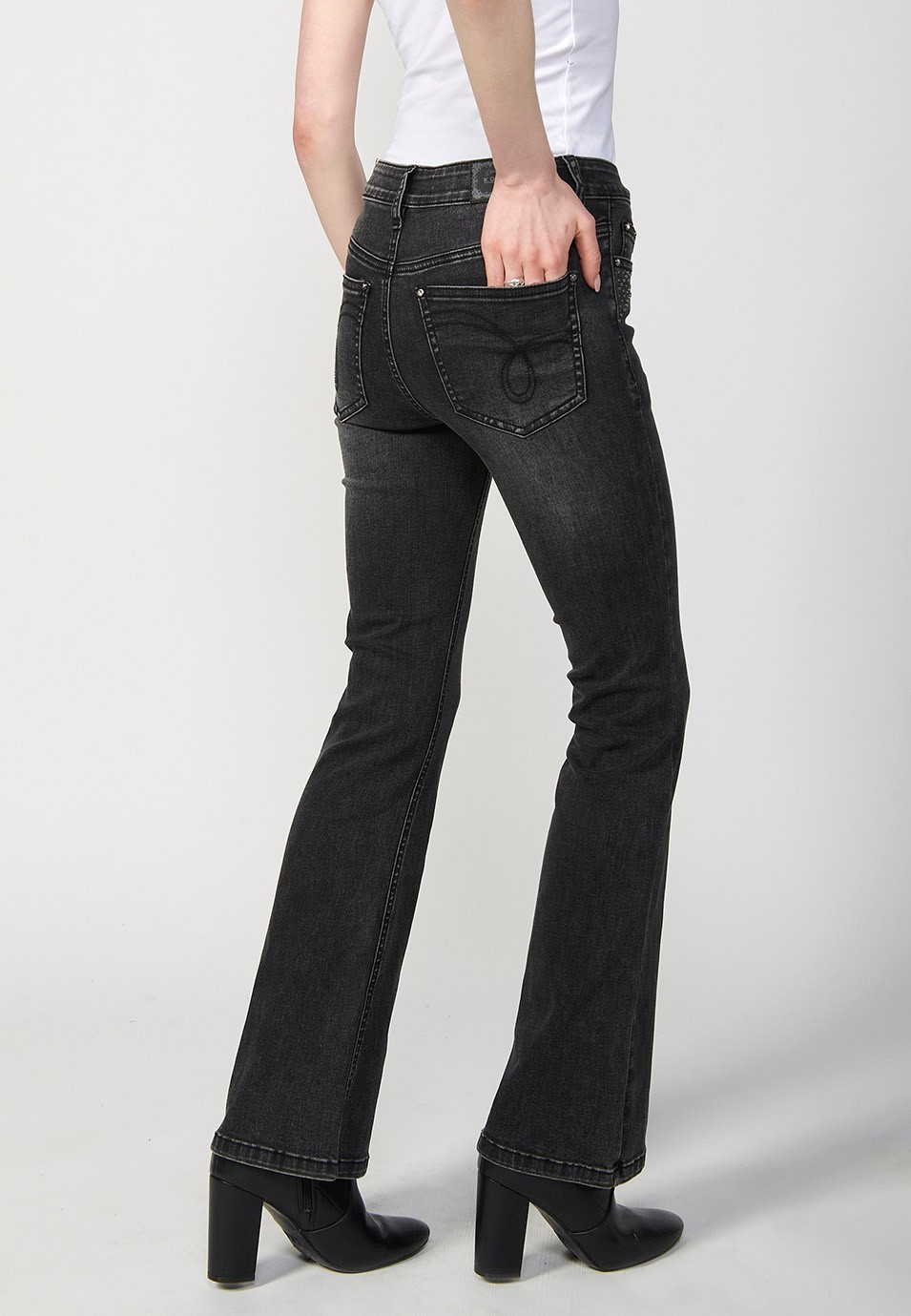 Pantalón denim boot cut cinco bolsillos, campana, color negro, con aplicaciones metalicas en bolsillos para Mujer