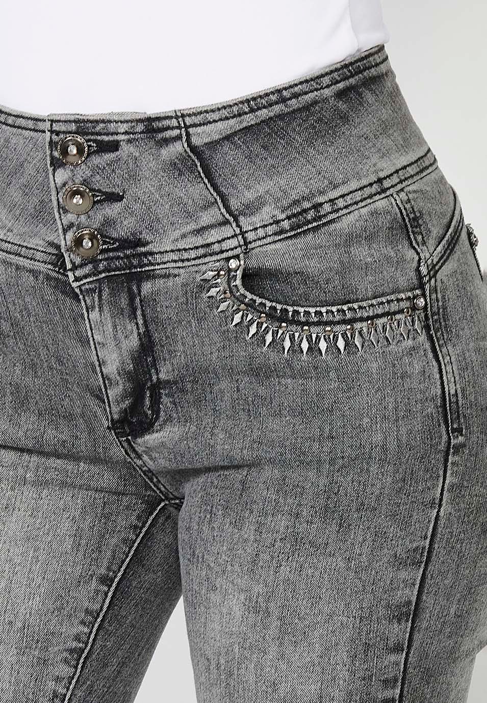 Pantalón denim push up ajustado cinco bolsillos y cintura fajín con detalles bordados y aplicaciones metálicas para mujer en color gris