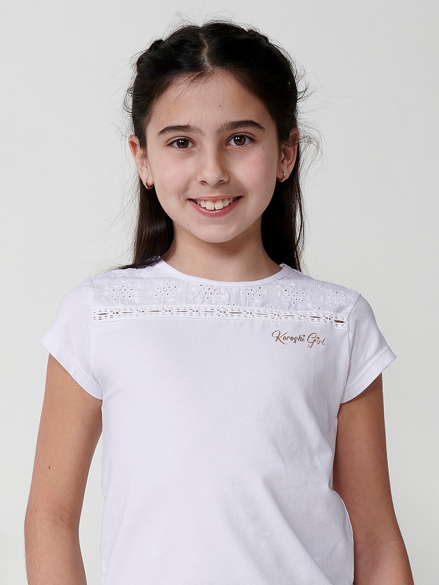 Girls' white top with waist tie, mesh yoke, and gold Koröshi logo
