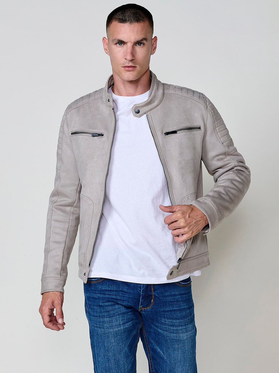 Cazadora de hombre en color piedra con cuello alto, bolsillos y cierre delantero de cremallera. Tejido 100% poliéster resistente y ligero.