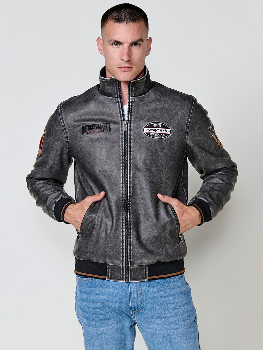 Cazadora gris de hombre con cuello alto, acabados en rib, cremallera, bolsillos y detalle de letras en la espalda. Tejido 100% poliéster.