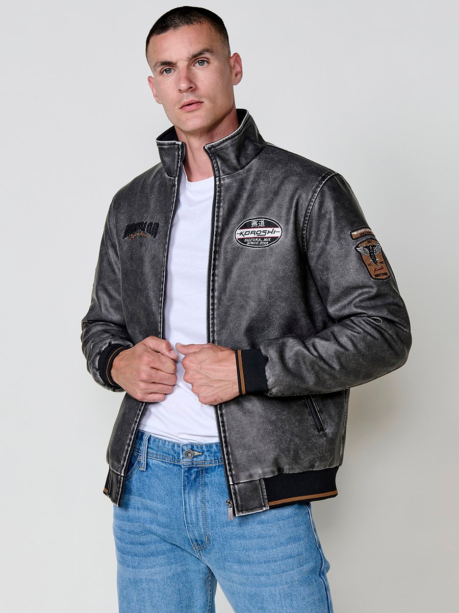 Cazadora gris de hombre con cuello alto, acabados en rib, cremallera, bolsillos y detalle de letras en la espalda. Tejido 100% poliéster.