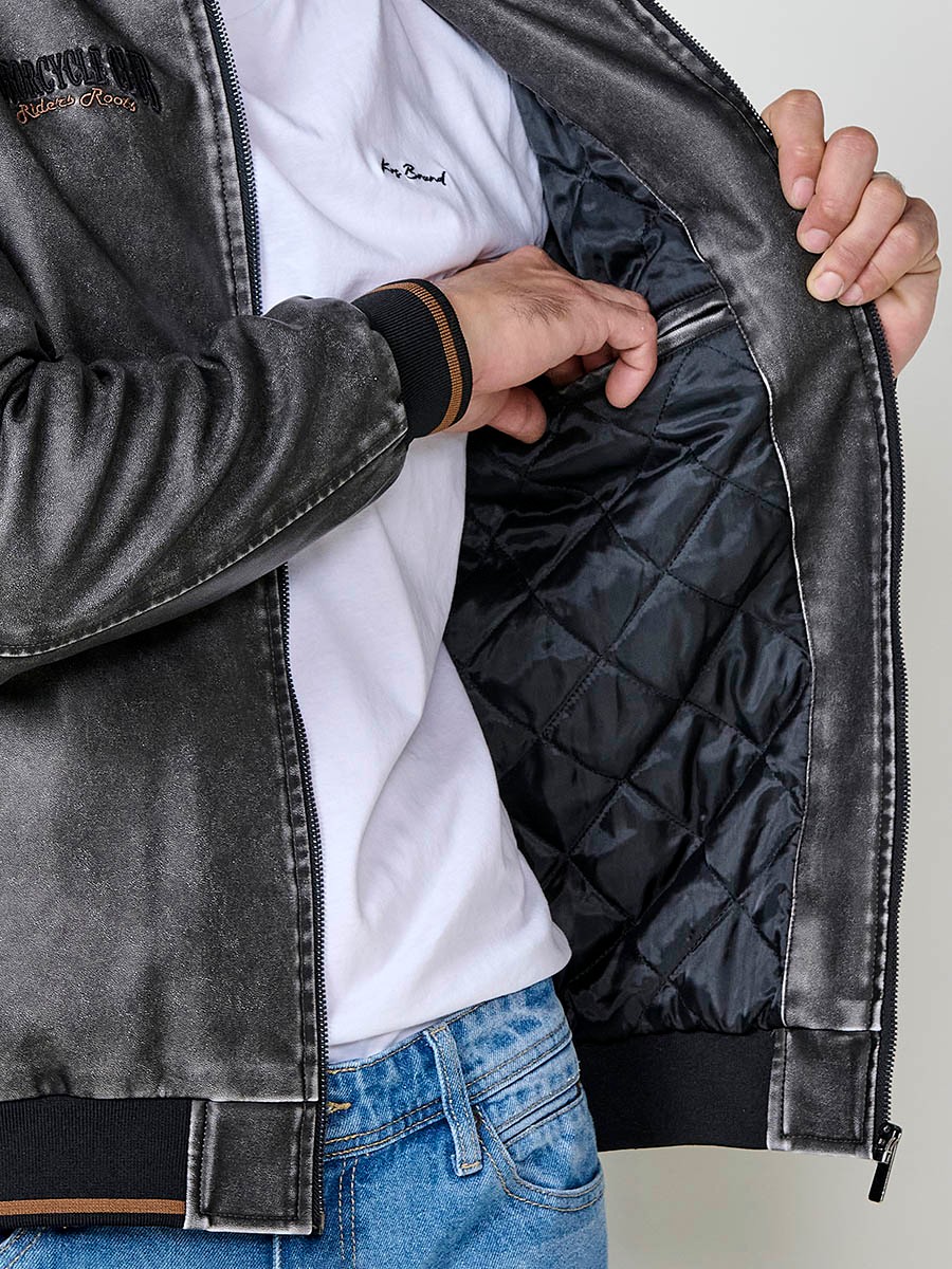 Cazadora gris de hombre con cuello alto, acabados en rib, cremallera, bolsillos y detalle de letras en la espalda. Tejido 100% poliéster.